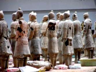 Rows of figures awaiting reconstruction.<br>The process is a giant jigsaw puzzle whose pieces may yet be removed from the earth