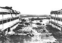 Looking out toward the flight line from the courtyard between heavily damaged Wing E (left) and Wing D of the big barracks at Hickam Field