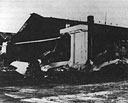 wrecked P-40Bs sit in front of an equally wrecked Hangar 3 at Wheeler Field