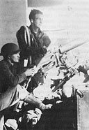 Wheeler Field personnel manning a 30-caliber machine gun set up behind the main barracks