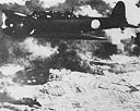 A Nakajima B5N (Kate) horizontal bomber flying over Hickam's burning flight line