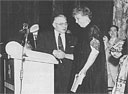 Herbert A. Bradley, Sr. greets First Lady Eleanor Roosevelt at the podium where she spoke to a meeting of the 100,000-member International Chemical Workers Union of the American Federation of Labor. Bradley, Sr. was the union president 1944-1954.