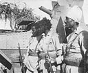 Robi the Shifta, with two of his compatriots, inspects South African armoured cars at Marsabit. <i>(Photo:</i> H. Klein.)