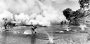 TROOPS WEARING GAS MASKS cross a stream under a protective cover of
smoke during maneuvers (top); infantrymen and jeeps
(<font size=-1><sup>1</sup>/>4</sup>-ton 4x4 truck) crossing 
a stream during training on New Caledonia, summer 1942.