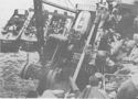 COAST GUARDSMEN UNLOAD TRUCKS AND OTHER SUPPLIES BY LANDING BARGES