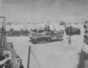 U.S. COAST GUARDSMEN UNLOAD THE SUPPLIES THAT BACK UP THE INFANTRY AS THE INVASION OF SICILY CONTINUES