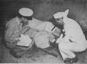 AMERICAN SOLDIER GIVES INFORMATION TO COAST GUARDSMAN EARL SAUTER (LEFT), CHIEF PHARMACIST'S MATE, OF MILWAUKEE, WISCONSIN, AFTER HE HAD BEEN TRANSFERRED FROM THE ITALIAN BEACHES ABOARD A COAST GUARD-MANNED ASSAULT TRANSPORT