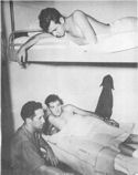 ABOARD A COAST GUARD MANNED ASSAULT TRANSPORT, TWO SOLDIERS, WOUNDED IN THE ITALIAN INVASION, ARE TREATED BY A NAVY PHARMACIST'S MATE