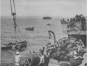 A WOUNDED MAN IS HOISTED ABOARD A COAST GUARD MANNED TRANSPORT DURING THE INVASION OF SICILY