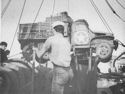 U.S. COAST GUARDSMEN SWING AN ARMY TRUCK OVERSIDE AS THEIR COMBAT TRANSPORT LIES OFF A BRIDGEHEAD ESTABLISHED AT PAESTERNUM