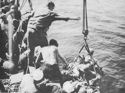 U.S. COAST GUARDSMEN HELP SLIGHTLY WOUNDED SOLDIERS COME ABOARD THE COMBAT TRANSPORT LYING OFF PAESTERNUM, JUST SOUTH OF SALERNO