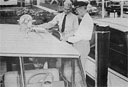 Robert S. Paris, part owner of yacht 'Riptide' foreground and Coast Guard Auxiliary 
Inspector Flotilla #52, Ralph Bonniville, inspect stores aboard yacht 'Riptide' 
berthern Southern Yacht Marine at the Gramby Street Bridge, Norfolk, Virginia