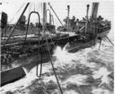 Fueling two ships at one time became the norm in the latter part of World War II. Here, Kankakee refuels light cruiser Montpelier (CL-57) in the Solomons on 13 January 1944 while a Fletcher-class destroyer approaches to starboard to receive fuel from that side of the oiler. Note the modifications that have been made to improve oiling at sea; particularly prominent are the large combination kingpost/ventilator shafts aft with their huge fueling booms. Other notable features include elevated cargo winches, a spar deck with its cargo of lube oil drums, and the addition of twin 40 mm gun positions atop the after deck house. (National Archives)