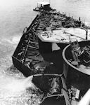 Image: 80-G-38812 Salvage operations on California showing removal of water from forecastle.