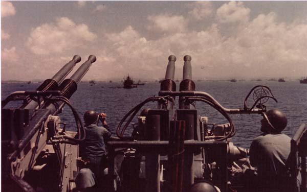 Crewmen on a 40mm quad on board West Virginia (BB 48) keep watch during the landings at Okinawa, 1 April 1945.
