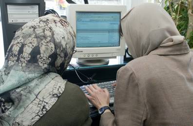 Two Iranian women work at an internet cafe in Tehran