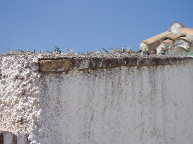 broken glass embedded on the top of a wall
