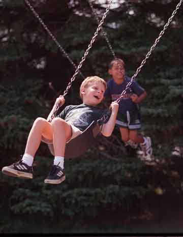 Children swinging in sunlight