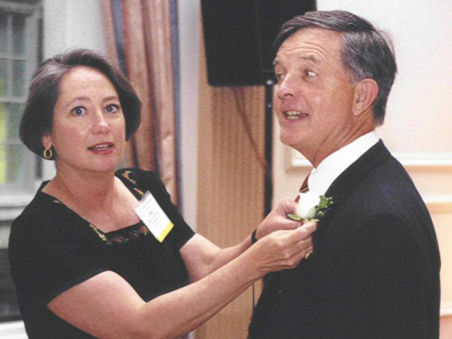 Linda Paschal helps NewsBank president Dan Jones prepare to receive a special recognition award for publication of the News Division's 75th anniversary Program.