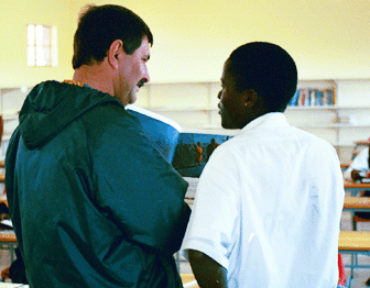 A teacher and student at DD Mabuza Comprehensive High School look at a new picture book together.