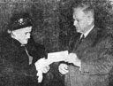 Mrs. Etta S. Jones receives from Secretary Ickes a check for $6887.54,
covering her salary for the years she spent as a prisoner in Japan.
She was captured on Attu.