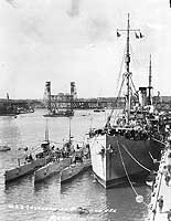 Photo # NH 71012: USS Savannah at Portland, Oregon, with submarines alongside, during the 1920s.  Photographed by Peck.