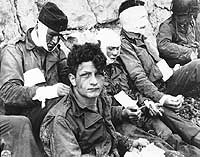 Photo # SC-189919:  Wounded Soldiers receive cigarettes and food after they stormed Omaha Beach, 6 June 1944