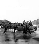 COAST GUARDMEN TRYING TO FREE AN LCVP after discharging its load of men and supplies