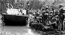Amphibian tractor, LVT(1), passing men who have stopped to rest