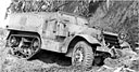 HALF-TRACK PERSONNEL CARRIER M3 mounting a .30-caliber machine gun parked at base of hill