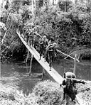MEN CROSSING AN IMPROVISED FOOTBRIDGE, 15 November