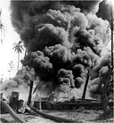 TAR BARRELS BURNING after a Japanese bombing raid, May 1943
