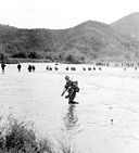 AMERICAN AND AUSTRALIAN TROOPS CROSSING A RIVER near Salamaua