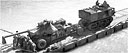 TRACTOR TOWING A 155-MM. GUN OVER A PONTON CAUSEWAY reaching from an LST to shore on Saipan