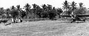 FILIPINOS IN A RICE FIELD watching an artillery cub plane prepare to take off near Angio