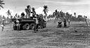 Filipinos working with U.S. engineer troops assembling steel matting on an airstrip at Lingayen