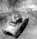 MEDIUM TANK M4A1, modified, firing on an enemy position in the hills east of Manila