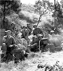 INFANTRYMEN firing a .30-caliber water-cooled machine gun M1917A1 at the enemy in the hills of Luzon