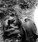 60-MM. MORTAR CREW FIRING at enemy positions on Mindanao