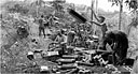 SHELL CASES BEING OPENED in preparation for an 81-mm. mortar attack in the hills of Mindanao