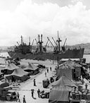 THE FIRST BIG U.S. SHIP TO ENTER NAHA HARBOR, Okinawa after the fighting ended