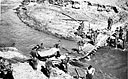 men stop to make repairs on a bridge which was damaged by the pack train