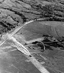 DOUGLAS C-47 TRANSPORT taking off in a cloud of dust from an airstrip near Man Wing, Burma