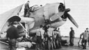 Air delivery section Marines and sh8ip's crew of USS Sargent Bay load a TBM with supplies to be dropped to Tenth Army troops