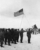 To the Colors sounds as the American flag is raised over Wake Island
