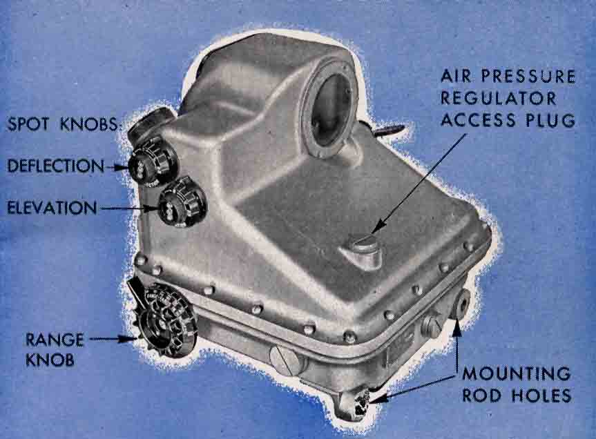 Front quarter view of sight showing: spot knobs for defelection and elevation, range knob, air pressure regulator access plug, and mounting rod holes.